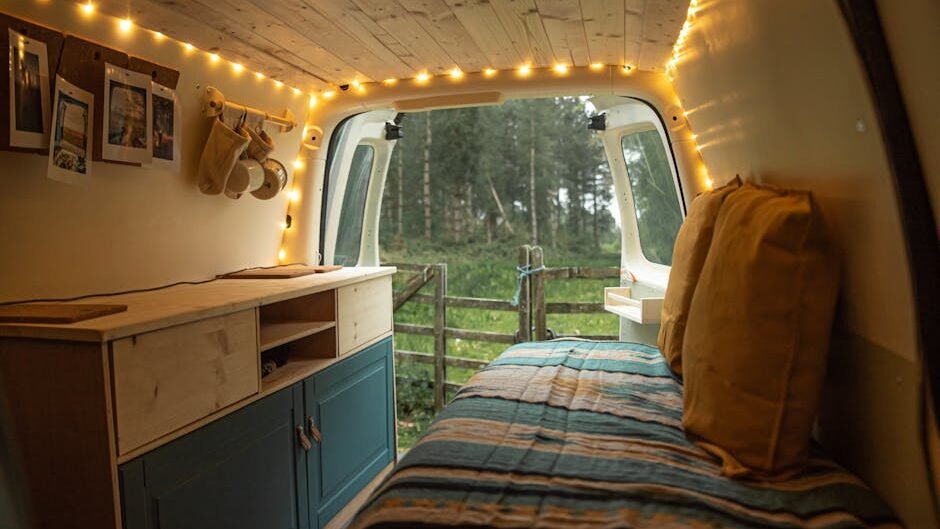 Charming van interior with string lights and forest view, perfect for camping enthusiasts.