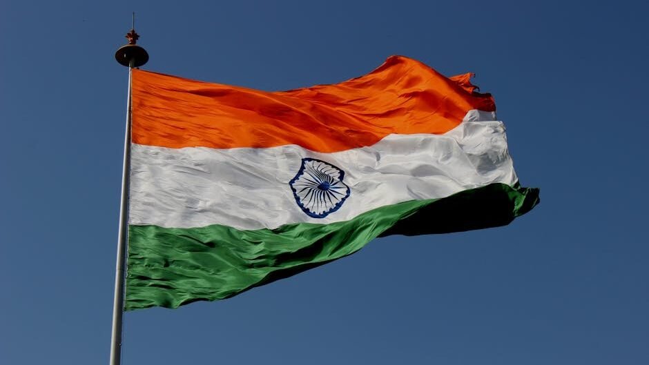 The Indian national flag waves proudly against a clear blue sky, symbolizing unity and pride.