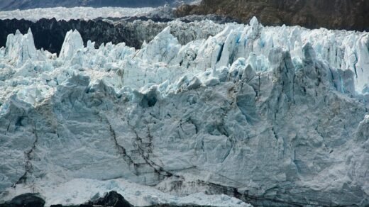 A breathtaking view of a massive glacier in Alaska, showcasing its icy formations and rugged beauty.