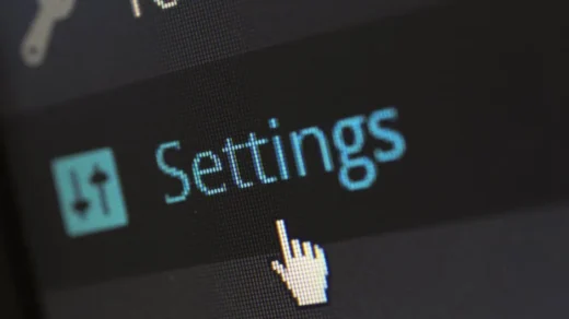 A close-up photo of a computer screen showing the settings button with a cursor hovering over it.