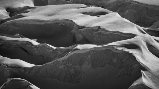Captivating black and white photo of Saas Fee's snowy mountain formations.