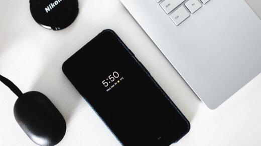 black Android smartphone beside grey laptop computer