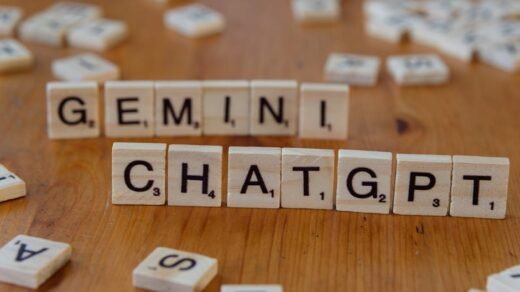 Close-up of wooden Scrabble tiles spelling Gemini and ChatGPT on a wooden surface.