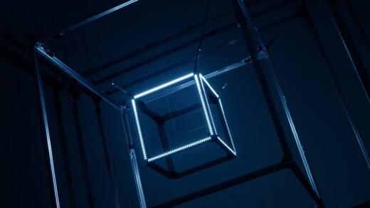 Close-up of illuminated geometric cubes hanging with metal frames in a dark setting.