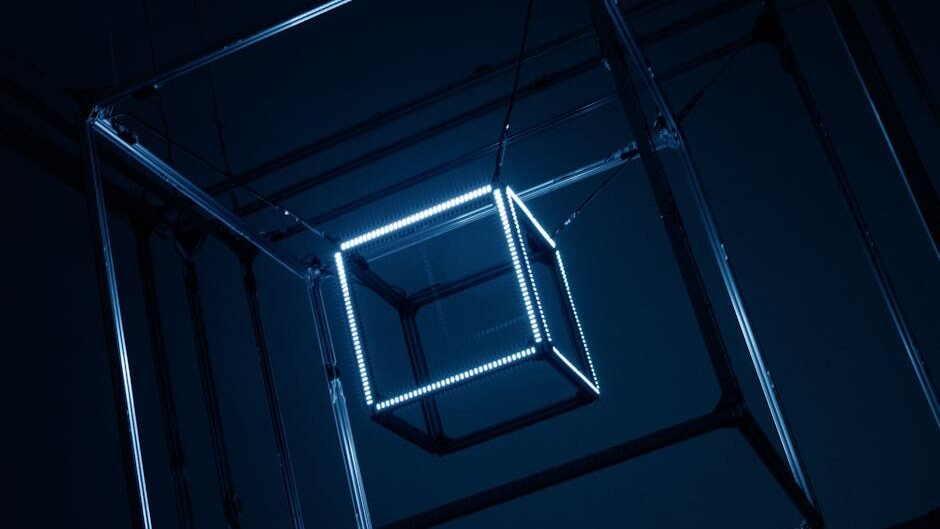 Close-up of illuminated geometric cubes hanging with metal frames in a dark setting.