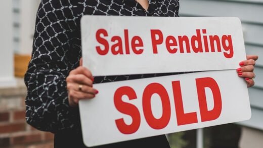 A businesswoman holding 'Sale Pending' and 'Sold' signs indicating a successful real estate transaction.