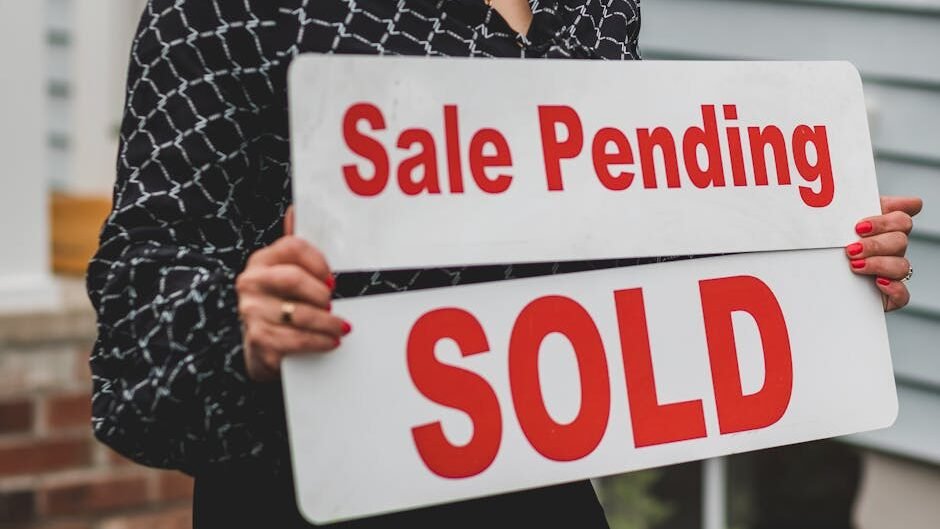 A businesswoman holding 'Sale Pending' and 'Sold' signs indicating a successful real estate transaction.