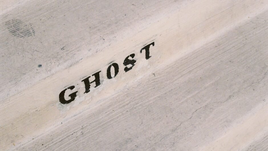 A close up of the word ghost written on a piece of wood