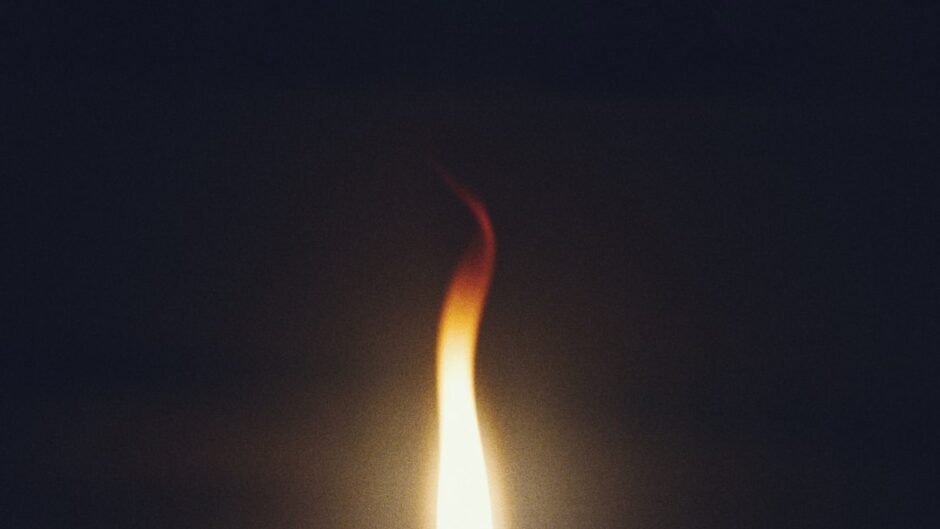 A single flame burning against a dark background