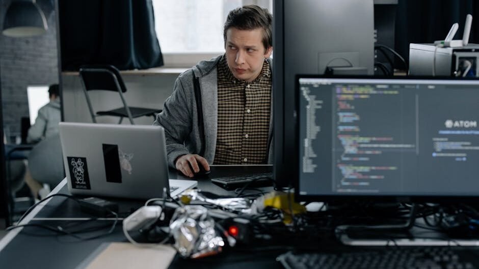 A programmer in a modern office working on computer code, showcasing a focused work environment.