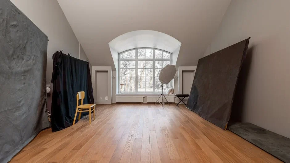 Spacious photography studio with angled ceilings and wooden floors, ideal for creative shoots.