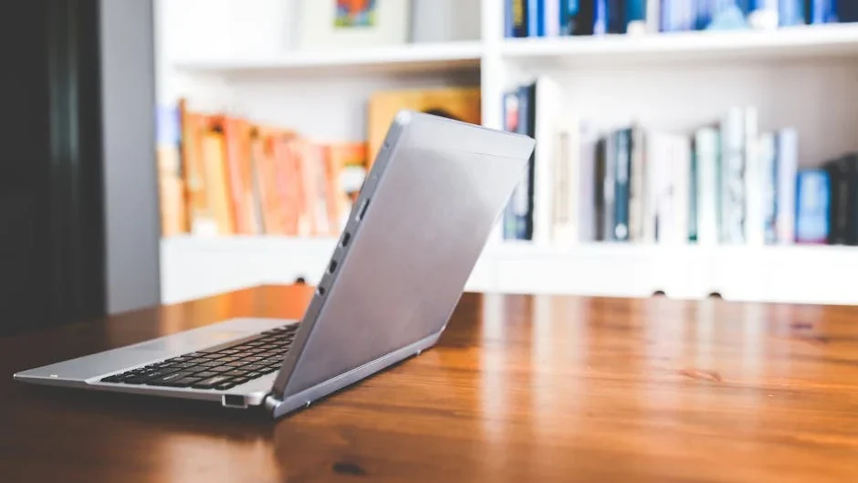 Elegant laptop on a wooden desk in a well-organized modern home office environment, perfect for remote work inspiration.