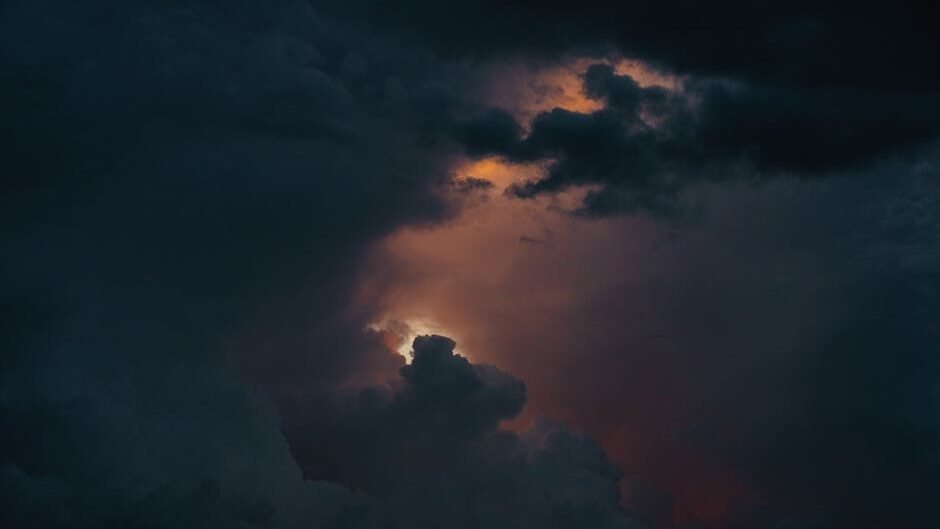 A captivating view of a dramatic stormy sky with glowing clouds breaking through darkness.