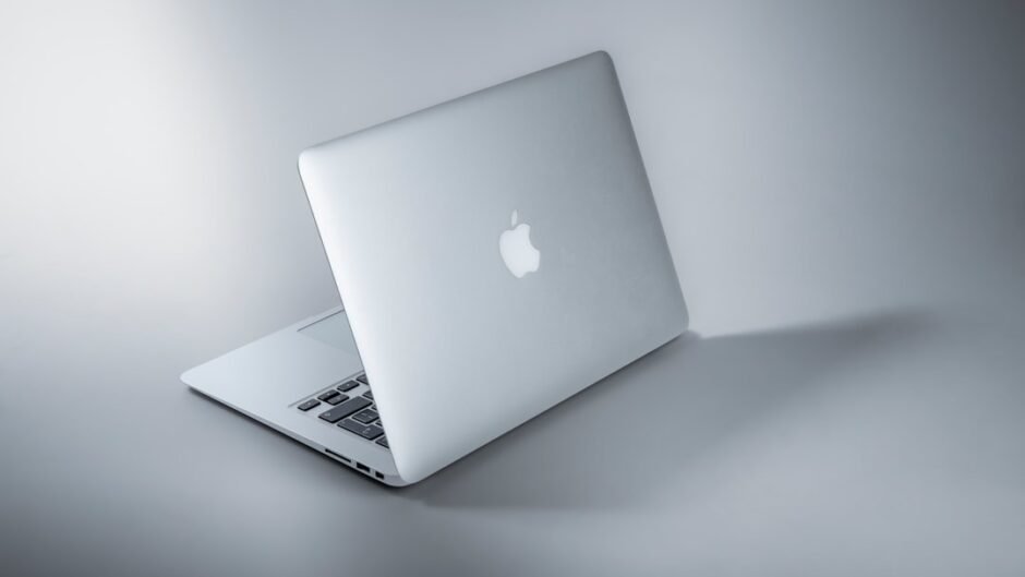 silver macbook on white table