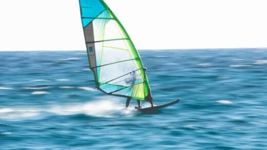 green and white sail boat on sea during daytime