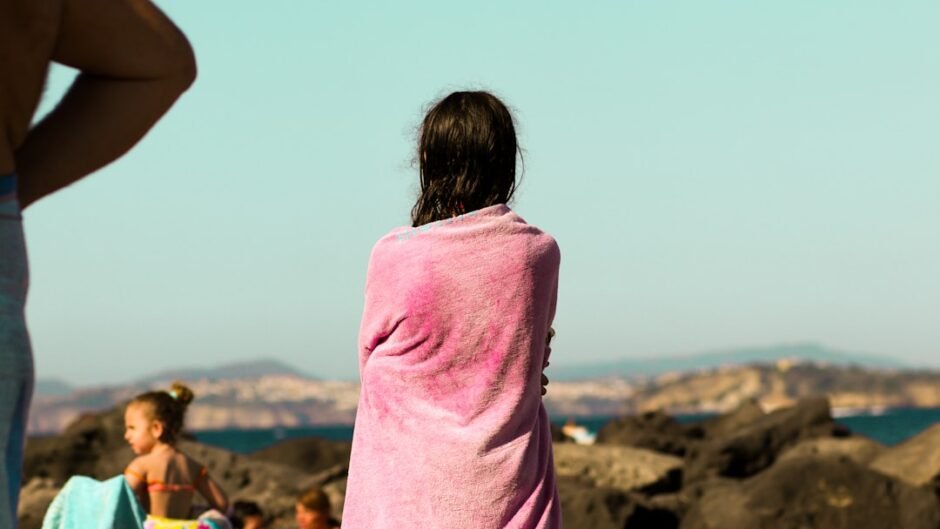 A woman in a pink towel standing on a beach