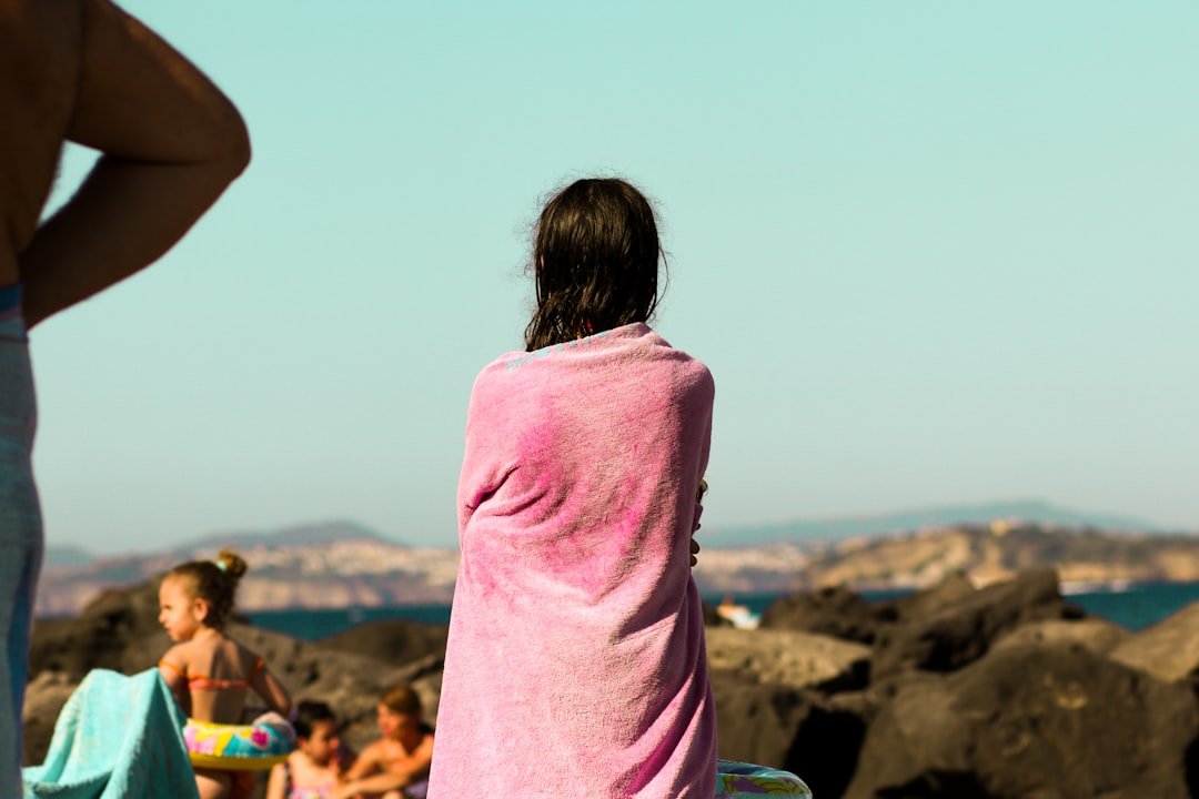 A woman in a pink towel standing on a beach