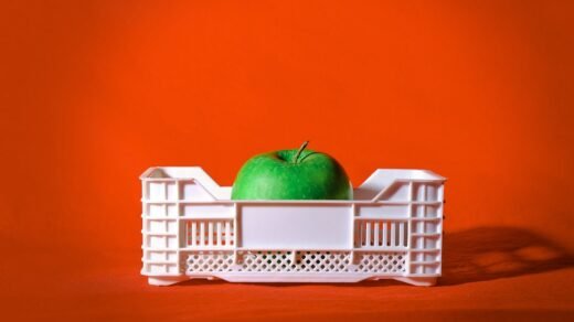 red apple on white plastic crate